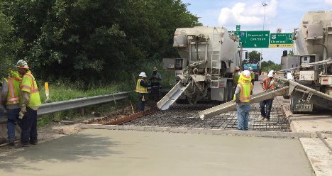 Crew placing concrete beside a freeway