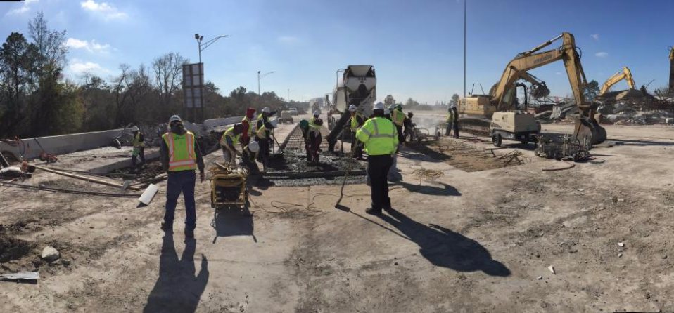 ISI crew in safety vests on an active job site with an excavator and concrete truck