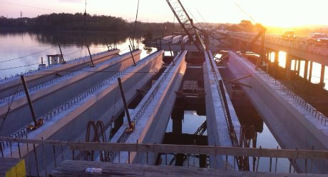 Bridge girders set over the water at sunset